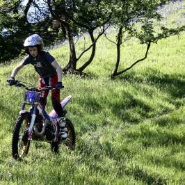 a man riding a bicycle on a grassy field