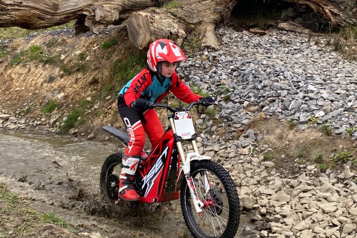 a man riding a motorcycle down a dirt road