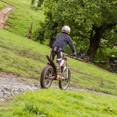 a man riding a motorcycle down a dirt road