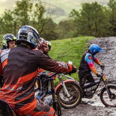 a man riding a motorcycle down a dirt road