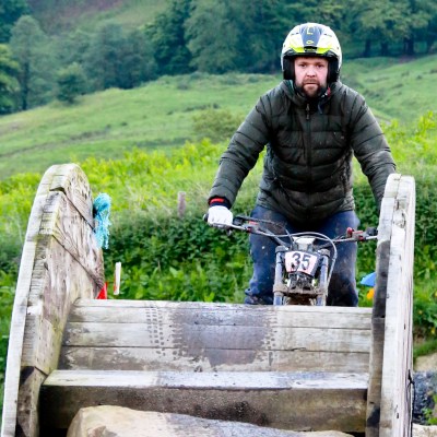 a man riding on top of a wooden fence