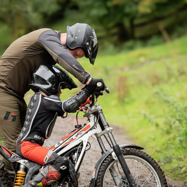 a man riding a motorcycle down a dirt road